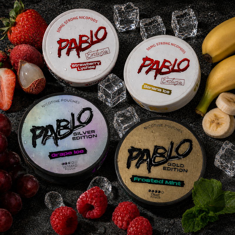 A selection of Pablo nicotine pouch cans in grape ice, frosted mint, strawberry lychee and banana ice flavours, all surrounded by various fruit and ice cubes.